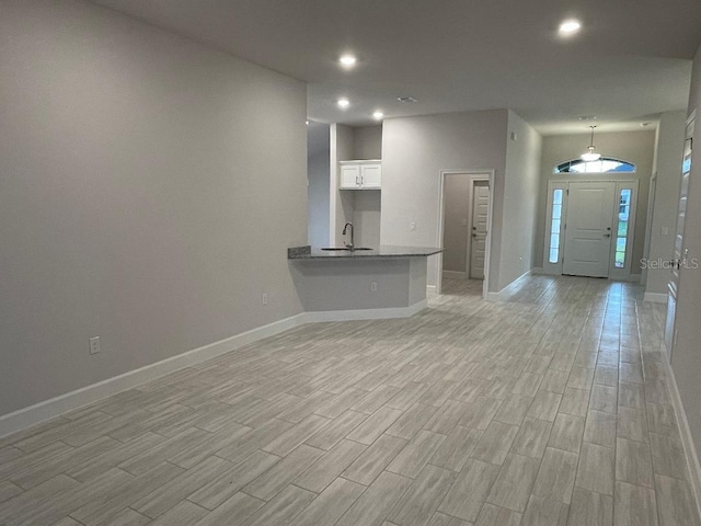 unfurnished living room featuring sink