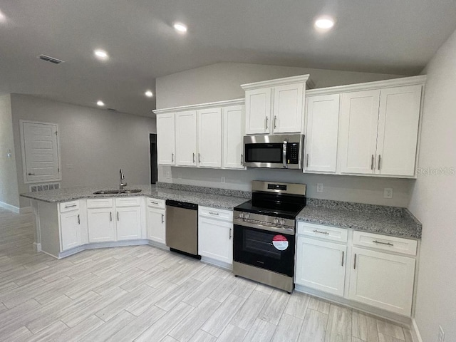 kitchen featuring sink, kitchen peninsula, white cabinets, and stainless steel appliances