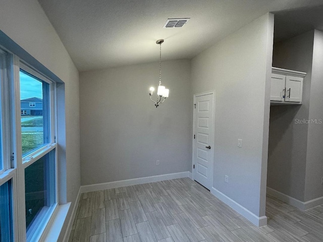 spare room with an inviting chandelier