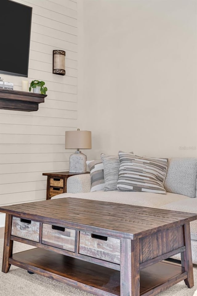 living room with light colored carpet and wooden walls