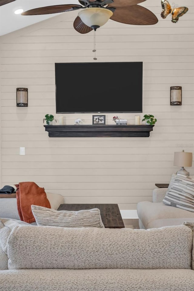 living room with vaulted ceiling and wooden walls