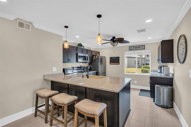 kitchen featuring a kitchen bar, stainless steel appliances, kitchen peninsula, ceiling fan, and crown molding