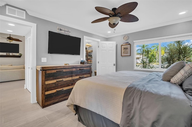 bedroom featuring ceiling fan, ornamental molding, and a closet