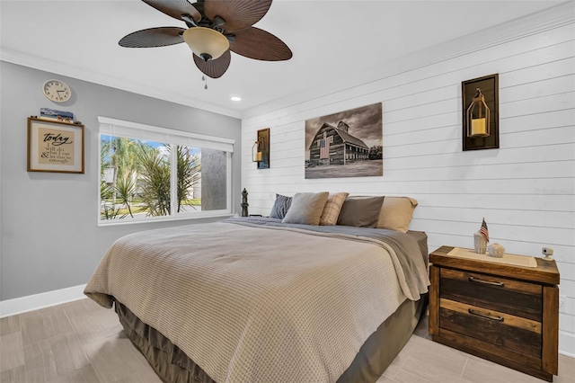 bedroom with ceiling fan, ornamental molding, and wood walls