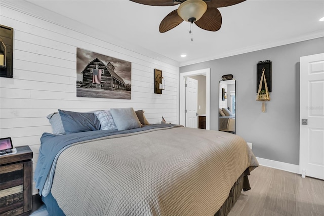 bedroom with ceiling fan, wood-type flooring, crown molding, and wood walls