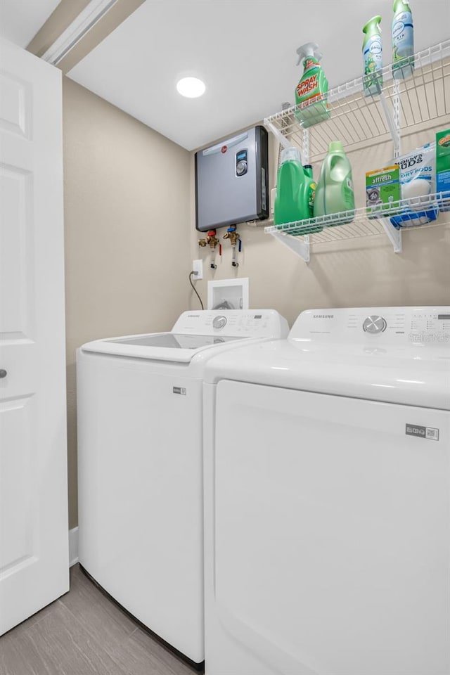 clothes washing area featuring washer and dryer and light hardwood / wood-style floors