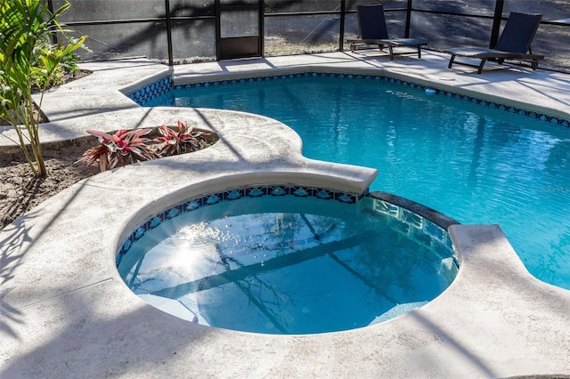 view of swimming pool featuring an in ground hot tub