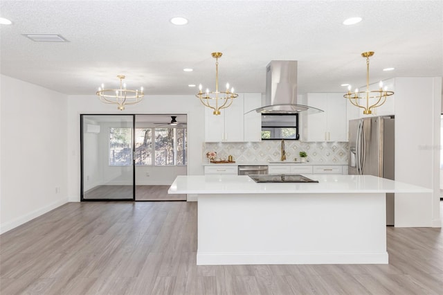 kitchen featuring white cabinets, a center island, backsplash, hanging light fixtures, and island range hood