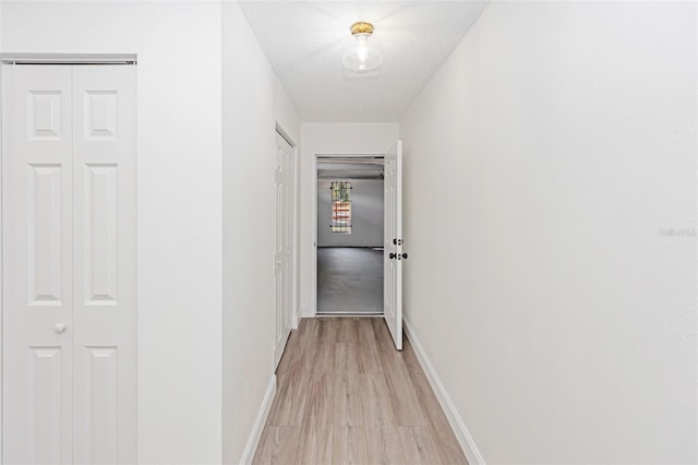 hallway featuring a textured ceiling and light wood-type flooring