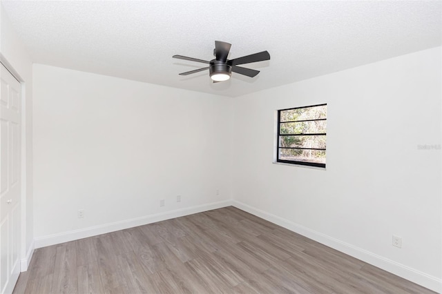 unfurnished room featuring a textured ceiling, ceiling fan, and light hardwood / wood-style flooring