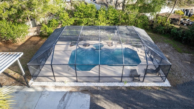 view of swimming pool with a patio area and glass enclosure