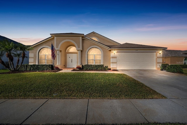 view of front of house featuring a garage and a lawn