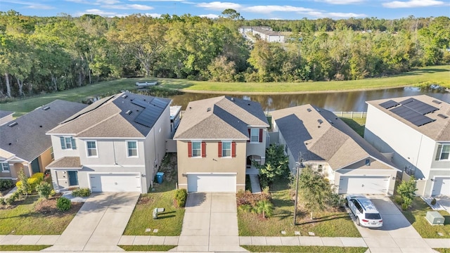 aerial view with a residential view, a view of trees, and a water view