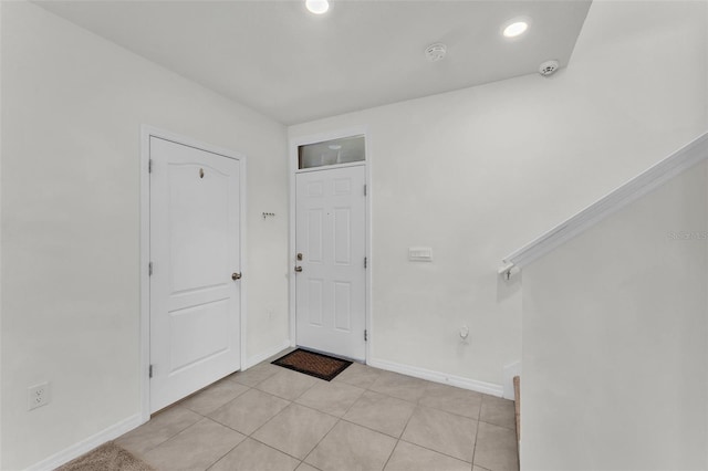 foyer entrance featuring light tile patterned flooring, recessed lighting, and baseboards