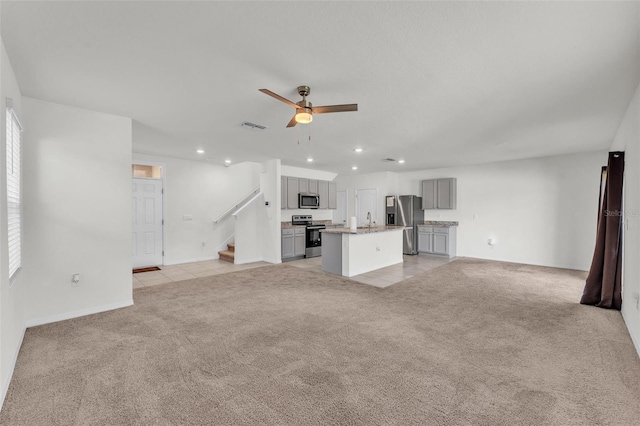 unfurnished living room featuring light tile patterned floors, light carpet, recessed lighting, and a ceiling fan