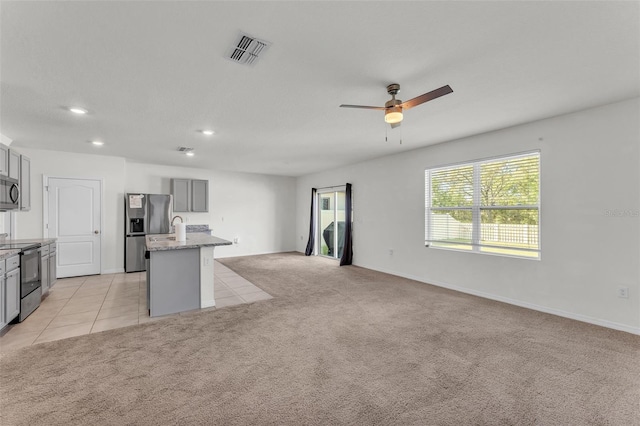 kitchen featuring visible vents, open floor plan, light carpet, gray cabinets, and stainless steel appliances