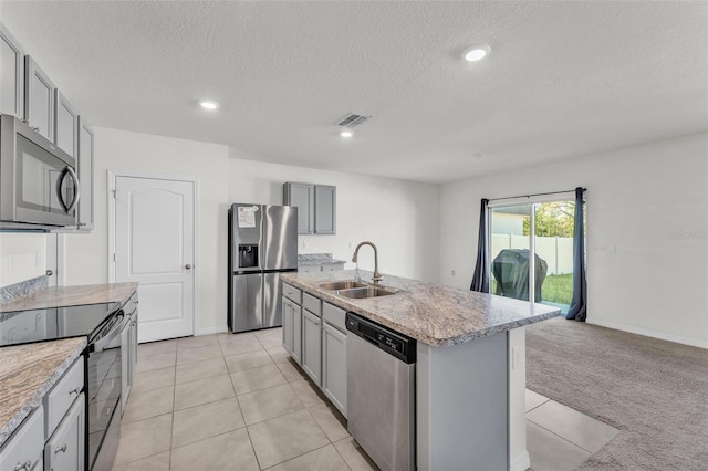 kitchen featuring a sink, light colored carpet, gray cabinets, and stainless steel appliances