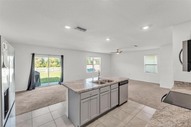 kitchen with light carpet, open floor plan, stainless steel appliances, and a sink