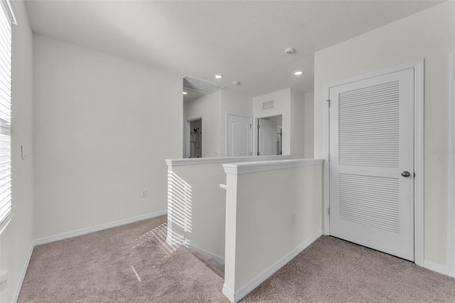 hallway with a wealth of natural light, baseboards, an upstairs landing, and carpet floors