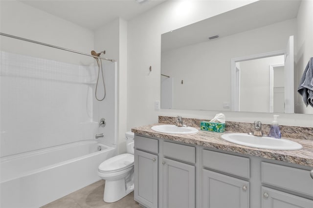 full bathroom featuring double vanity, tile patterned flooring, toilet, and a sink