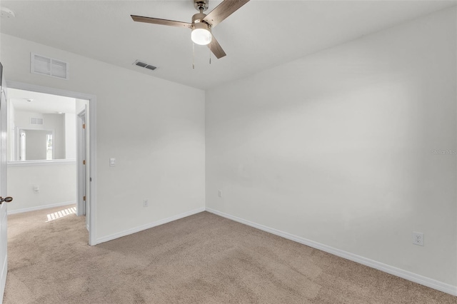 carpeted empty room featuring visible vents, ceiling fan, and baseboards