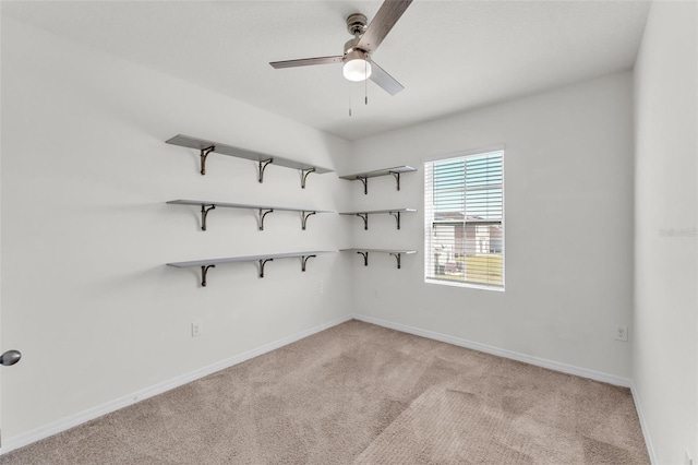 spare room with light colored carpet, baseboards, and ceiling fan