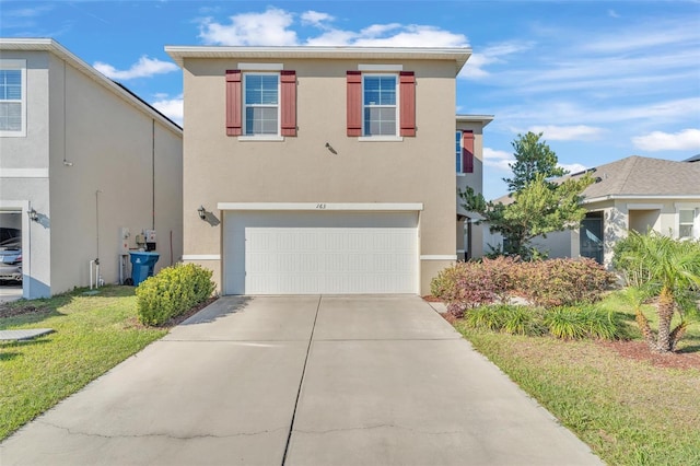 traditional home with stucco siding, an attached garage, and driveway