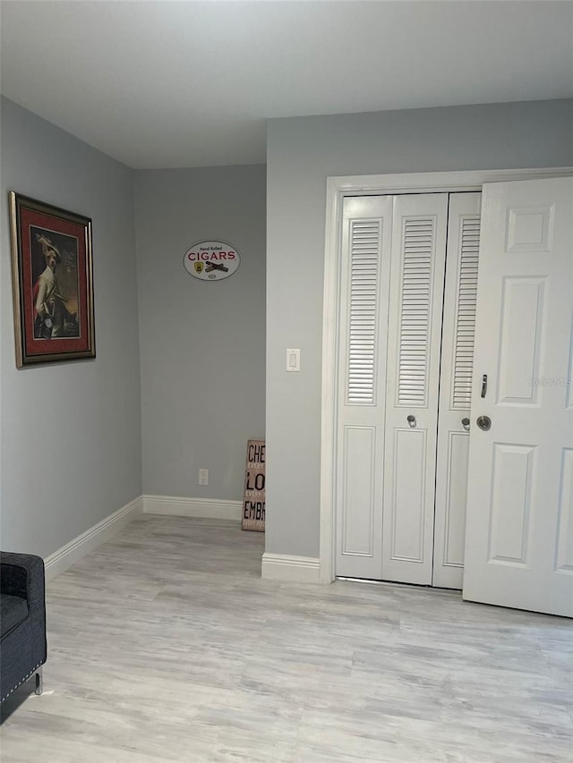 bedroom with light hardwood / wood-style flooring and a closet