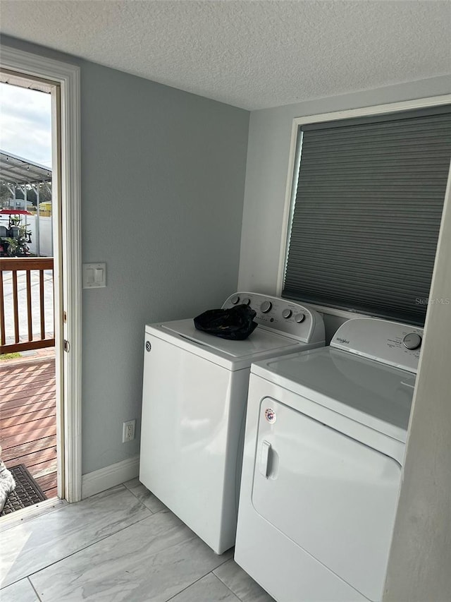 laundry room featuring washing machine and dryer and a textured ceiling