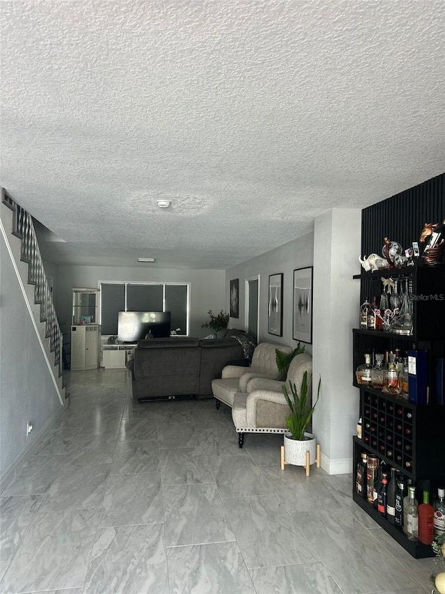 living room with indoor bar and a textured ceiling