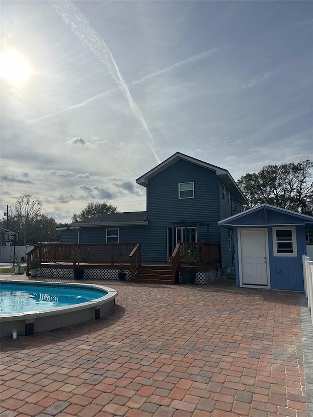 view of swimming pool with an outdoor structure and a deck