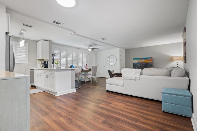 living room featuring ceiling fan, dark wood-type flooring, and sink