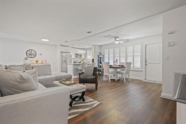 living room with ceiling fan and dark hardwood / wood-style flooring