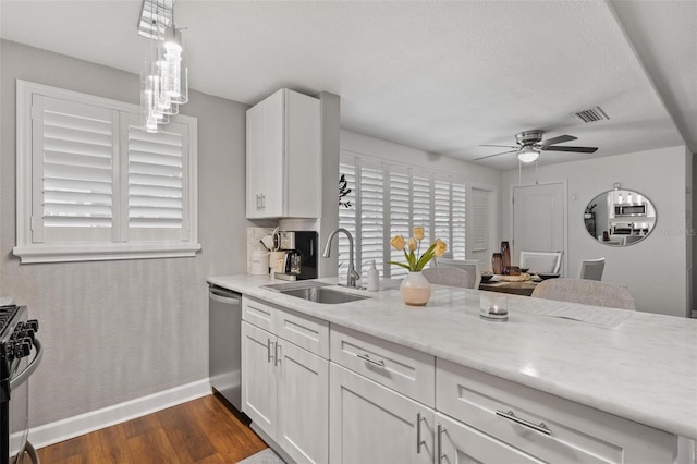 kitchen featuring white cabinets, decorative light fixtures, stainless steel appliances, sink, and dark hardwood / wood-style floors