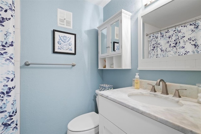 bathroom featuring toilet and vanity