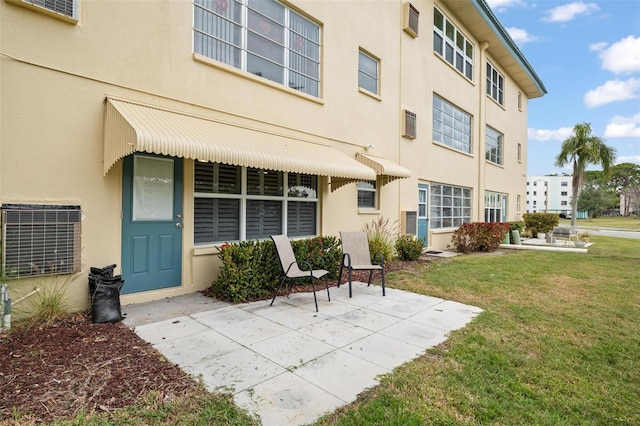 property entrance with a patio area and a yard