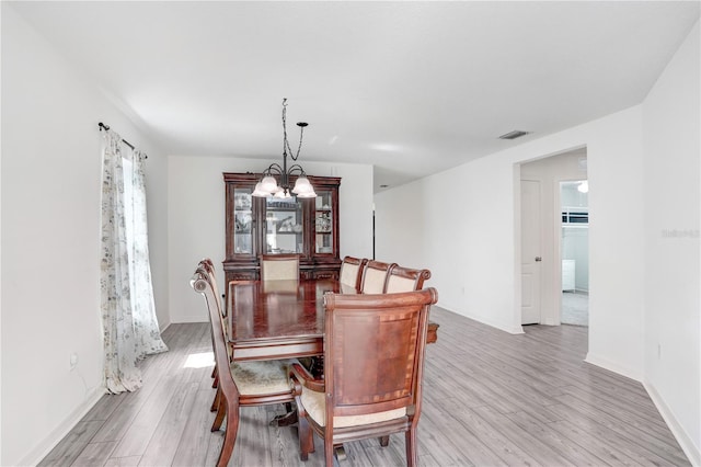 dining room featuring light hardwood / wood-style floors and a notable chandelier