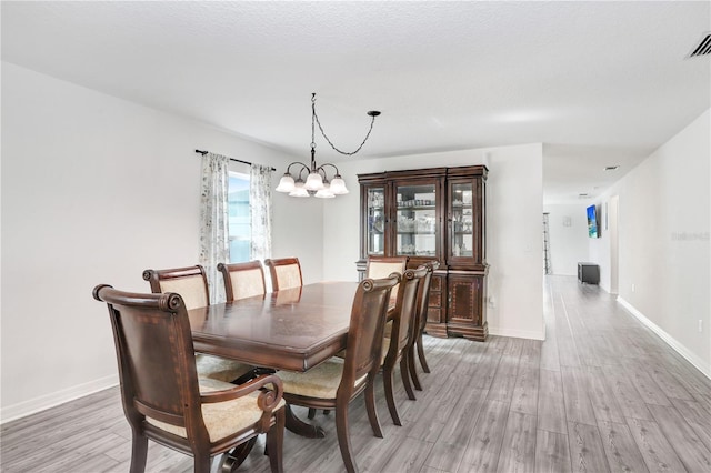 dining area featuring hardwood / wood-style floors and a notable chandelier