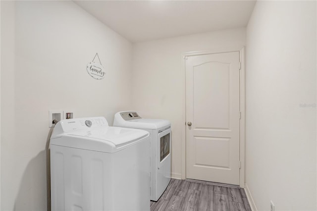 laundry room featuring light wood-type flooring and independent washer and dryer