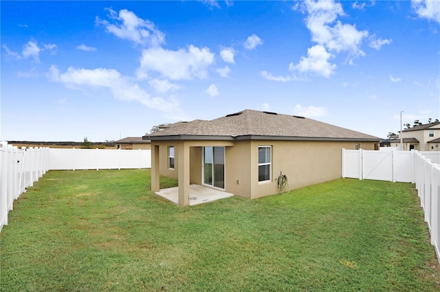 rear view of house featuring a yard and a patio