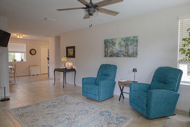 living area with light tile patterned flooring and ceiling fan