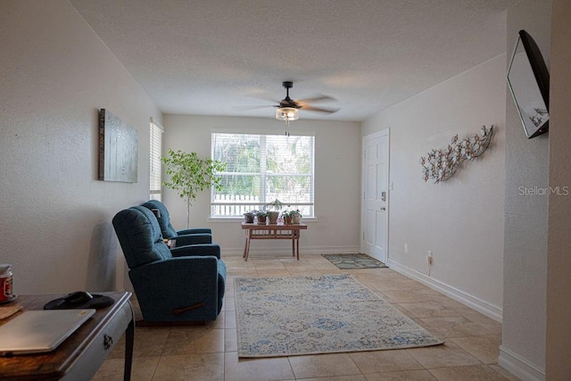 sitting room featuring light tile patterned flooring, ceiling fan, and a textured ceiling