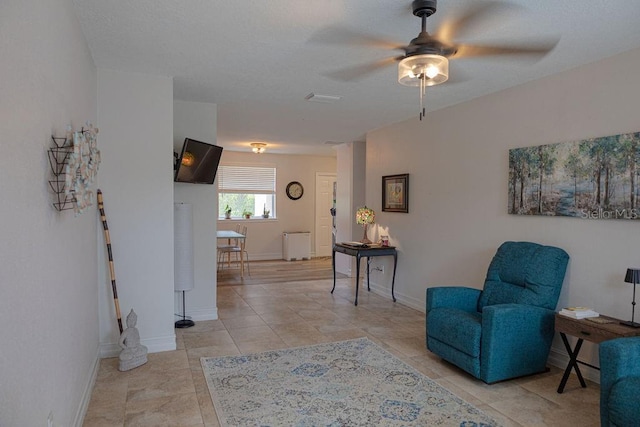 living area with light tile patterned flooring and ceiling fan