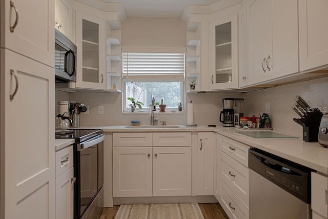 kitchen with tasteful backsplash, appliances with stainless steel finishes, sink, and white cabinets