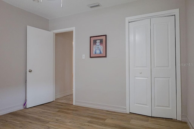 unfurnished bedroom with a closet and light hardwood / wood-style flooring