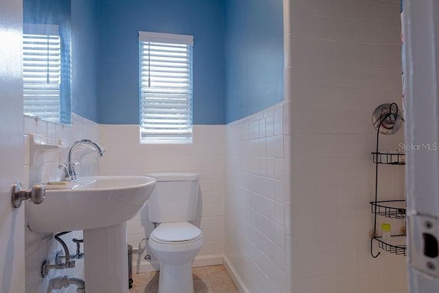 bathroom with tile walls, tile patterned floors, and toilet