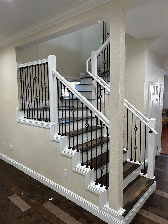 staircase with hardwood / wood-style floors and ornamental molding