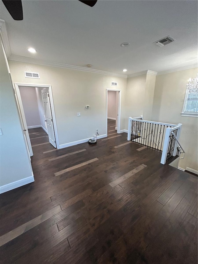 empty room featuring ceiling fan with notable chandelier, ornamental molding, and dark hardwood / wood-style floors