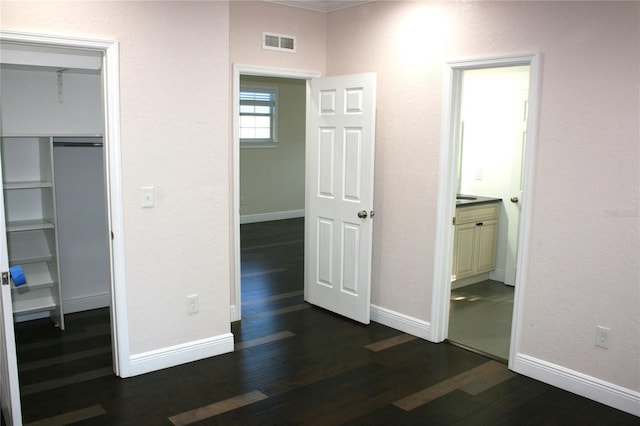 unfurnished bedroom featuring dark wood-type flooring and a closet