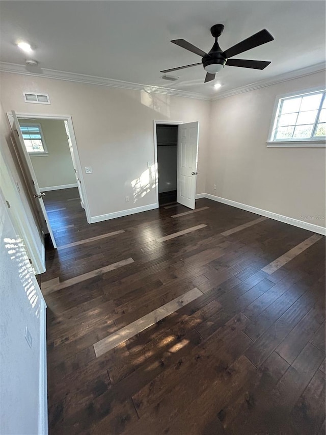 unfurnished room featuring ceiling fan, dark hardwood / wood-style floors, a wealth of natural light, and ornamental molding